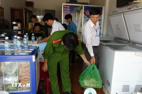 Công an Bình Phước kiểm tra thực phẩm bẩn tại cơ sở Tuyết Ánh, nơi cung cấp thực phẩm trong các bữa ăn cho công nhân của công ty. (Ảnh: Đậu Tất Thành/TTXVN)