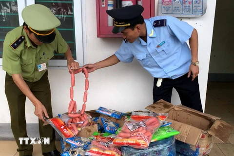 Lực lượng liên ngành thành phố Móng Cái bắt giữ lô hàng thực phẩm nhập lậu không rõ nguồn gốc. (Ảnh: Văn Đức/TTXVN)