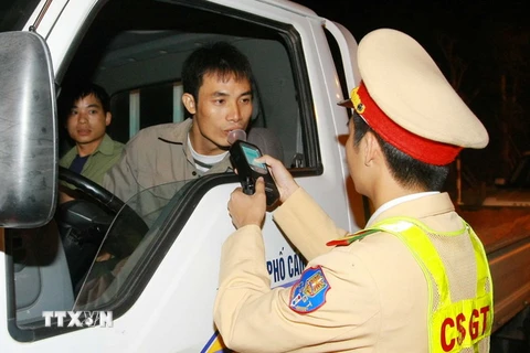 Cảnh sát giao thông kiểm tra nồng độ cồn của lái xe. (Ảnh: Doãn Tấn/TTXVN)