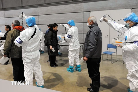 Nhân viên y tế Nhật Bản kiểm tra người tiếp xúc với bức xạ sau thảm họa hạt nhân Fukushima năm 2011. (Nguồn: EPA/TTXVN)