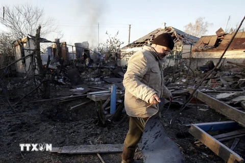 Người dân Ukraine thu dọn đống đổ nát của một ngôi nhà bị phá hủy sau vụ cháy nổ. (Nguồn: AFP/TTXVN)
