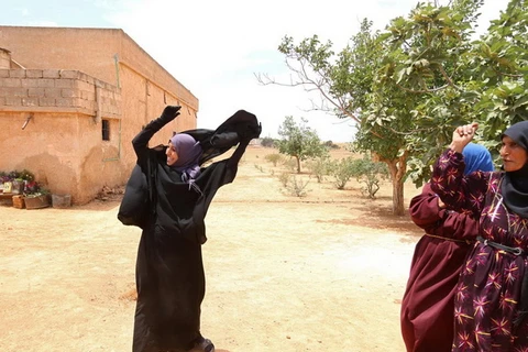 Phụ nữ ở ngôi làng nằm ở ngoại ô thành phố Manbij hân hoan cởi bỏ niqab. (Nguồn: Reuters)