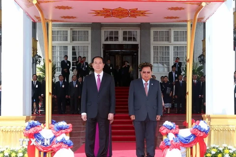 Chủ tịch nước Trần Đại Quang và Tổng Bí thư, Chủ tịch nước Lào Bounnhang Volachith trên bục danh dự. (Ảnh: Nhan Sáng/TTXVN)