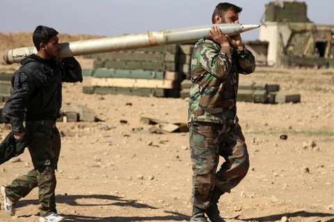Binh lính Syria chuẩn bị tên lửa tấn công vị trí của nhóm IS ở tỉnh Raqqa. (Nguồn: AP)