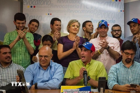 Thủ lĩnh phe đối Venezuela Henrique Capriles (áo xanh đội mũ) phát biểu tại buổi họp báo ở thủ đô Caracas. (Nguồn: EPA/TTXVN) 