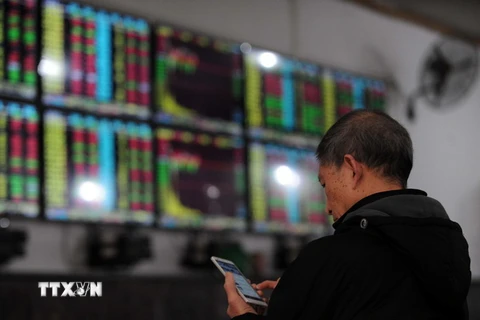 Nhà đầu tư theo dõi tỷ giá chứng khoán tại thành phố Vũ Hán, tỉnh Hồ Bắc, miền Trung Trung Quốc. (Nguồn: AFP/TTXVN)
