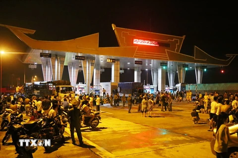 Người dân tập trung tại trạm thu phí cầu Hạc Trì để phản đối việc đặt trụ bêtông bên cầu Việt Trì. (Ảnh: Trung Kiên/TTXVN)