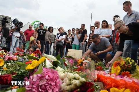 Thắp nến và đặt hoa tưởng niệm các nạn nhân vụ xả súng gần trung tâm Olympia, Munich ngày 23/7. (Nguồn: AFP/TTXVN)