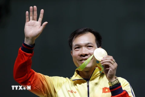 Xạ thủ Hoàng Xuân Vinh cùng tấm huy chương Vàng lịch sử. (Nguồn: EPA/TTXVN)