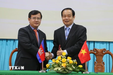 Ông Vương Bình Thạnh, Chủ tịch tỉnh An Giang (phải) và Ngài Lay Vannak, Tỉnh Trưởng tỉnh Takeo, Campuchia ký thỏa thuận hợp tác giữa hai tỉnh. (Ảnh: Công Mạo/TTXVN)