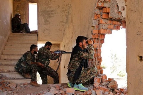 Các tay súng người Kurd chiếm giữ một tòa nhà bị hư hỏng tại Hasaka. (Nguồn: Reuters)