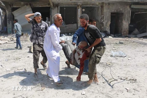 Nhân viên cứu hộ Syria chuyển nạn nhân bị thương tại Aleppo ngày 27/8. (Nguồn: AFP/TTXVN)