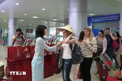 Tặng nón lá cho du khách Nga đến Việt Nam. (Ảnh: Tiên Minh/TTXVN)