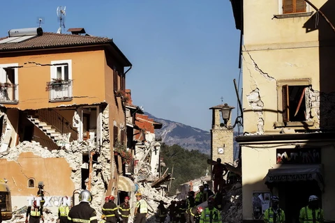 Lực lượng cứu hỏa, cứu hộ làm việc tại hiện trường đổ nát sau động đất tại Amatrice. (Nguồn: EPA/TTXVN)
