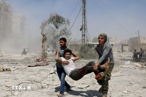 Chuyển nạn nhân bị thương trong vụ tấn công bằng bom thùng tại Aleppo ngày 27/8. (Nguồn: AFP/TTXVN)