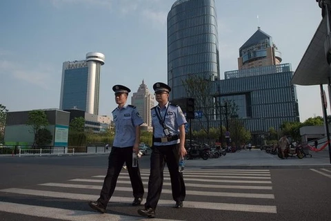 Hai sỹ quan cảnh sát tuần tra trên các đường phố vắng vẻ tại một trong những khu vực mua sắm vốn sầm uất ở Hàng Châu. (Nguồn: Getty Images)