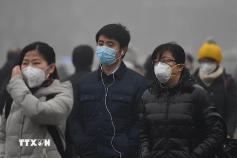 Người dân đeo khẩu trang để tránh không khí ô nhiễm tại Bắc Kinh, Trung Quốc. (Nguồn: THX/TTXVN)