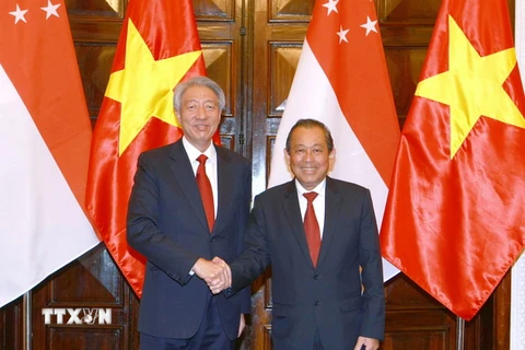 Phó Thủ tướng Thường trực Chính phủ Trương Hòa Bình đón và hội đàm Phó Thủ tướng Singapore Tiêu Chí Hiền. (Ảnh: Doãn Tấn/TTXVN)