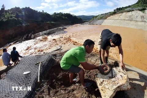 Công nhân trục vớt các thiết bị bị nước cuốn trôi tại hiện trường sự cố vỡ đường ống dẫn dòng Công trình thủy điện Sông Bung 2. (Ảnh: Trần Lê Lâm/TTXVN)