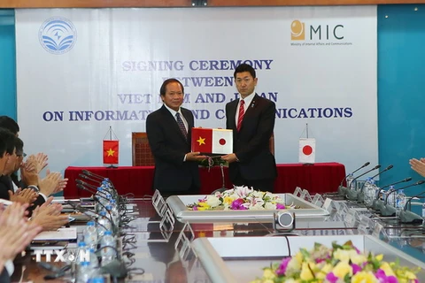 Bộ trưởng Bộ Thông tin và Truyền thông Trương Minh Tuấn và ông Jiro Akama, Thứ trưởng Bộ Nội Vụ và Truyền thông Nhật Bản bàn giao biên bản ký nhận hợp tác về lĩnh vực thông tin truyền thông giữa hai nước. (Ảnh: Huy Hùng/TTXVN)