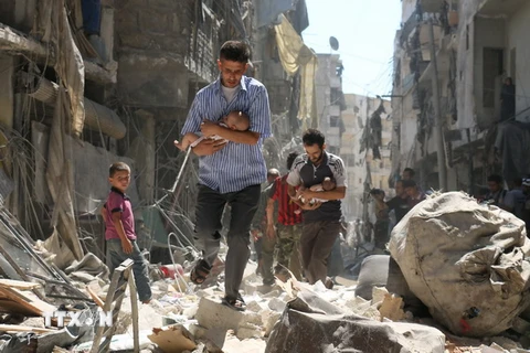 Chuyển các em nhỏ Syria ra khỏi một tòa nhà bị sập sau vụ không kích nhằm vào khu vực Salihin ở thành phố Aleppo, miền bắc Syria ngày 11/9. (Nguồn: AFP/TTXVN)