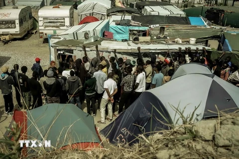 Người di cư xếp hàng nhận lương thực cứu trợ tại Calais, Pháp. (Nguồn: AFP/TTXVN)