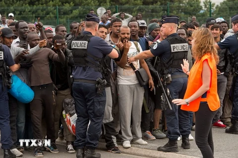 Cảnh sát giám sát, phân loại những người tị nạn tại Calais. (Nguồn: AFP/TTXVN)