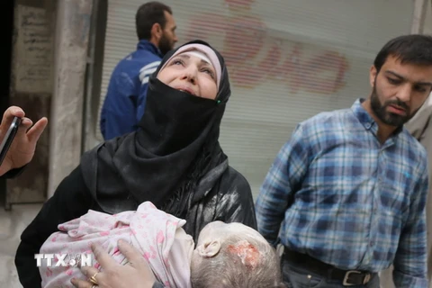 Nỗi đau của người mẹ Syria bên thi thể bé con sơ sinh sau xung đột tại al-Muasalat, phía Bắc thành phố Aleppo ngày 23/9. (Nguồn: AFP/TTXVN)