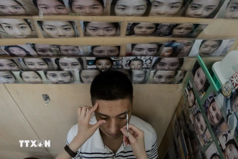 Một khách hàng được bà Li Chau-jing tạo lại dáng lông mày. (Nguồn: AFP/TTXVN)