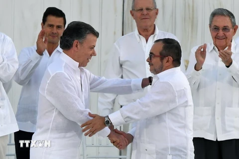 Tổng thống Colombia Juan Manuel Santos (thứ 2, trái) và thủ lĩnh FARC Timoleon Jimenez (thứ 2, phải) tại lễ ký kết thỏa thuận hòa bình ở Cartagena, Colombia ngày 26/9. (Nguồn: AFP/TTXVN)