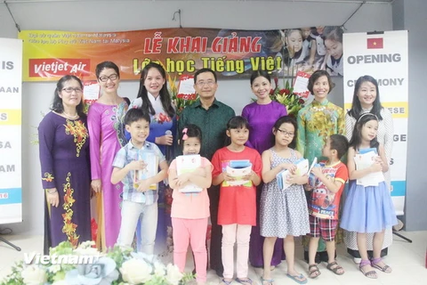Đại sứ Phạm Cao Phong tặng sách cho các học sinh của lớp học. (Ảnh: Hoàng Nhương/Vietnam+)