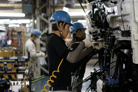 Công nhân làm việc tại dây chuyền sản xuất xe tải của Hãng Mitsubishi Fuso tại Kawasaki, Nhật Bản. (Nguồn: EPA/TTXVN)