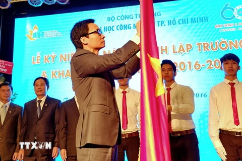 Phó Thủ tướng Vũ Đức Đam gắn Huân chương Độc lập Hạng Ba lên cờ truyền thống của Trường Đại học Công nghiệp Thành phố Hồ Chí Minh. (Ảnh: Thế Anh/TTXVN)