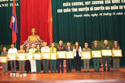 Các cán bộ chuyên gia, quân tình nguyện được trao tặng Huân, Huy chương của Nhà nước Lào. (Ảnh: Khiếu Tư/TTXVN)