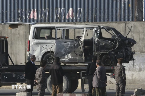Lực lượng an ninh Afghanistan chuyển chiếc xe bị phá hủy sau vụ đánh bom ở Kabul. (Nguồn: AP/TTXVN)