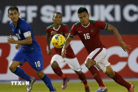 Cầu thủ Teerasil Dangda (trái), đội Thái Lan tranh bóng với các cầu thủ đội Indonesia. (Nguồn: AP/TTXVN)