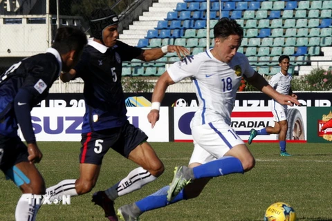 Cầu thủ Darren Yee Deng Lok (phải), đội Malaysia đi bóng trước sự truy cản của cầu thủ Soeuy Visal (giữa) đội Campuchia. (Nguồn: AP/TTXVN)