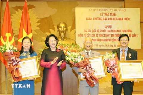 Chủ tịch Quốc hội Nguyễn Thị Kim Ngân trao Huân chương Độc lập hạng Nhất cho các đại biểu. (Ảnh: Trọng Đức/TTXVN)