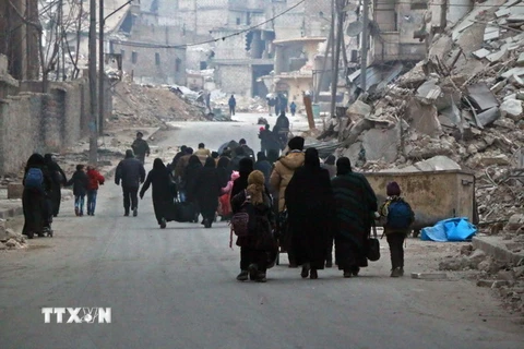Người dân Syria rời khỏi khu vực Sukkari để đến khu vực an toàn hơn do quân nổi dậy chiếm giữ ở Đông Nam thành phố Aleppo. (Nguồn: AFP/TTXVN)