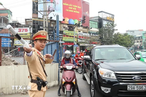 Cảnh sát giao thông Đội 6, Công an Thành phố Hà Nội làm nhiệm vụ phân luồng giao thông tại đường Xuân Thủy, quận Cầu Giấy. (Ảnh: Doãn Tấn/TTXVN)