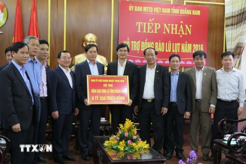 Đoàn công tác Đảng ủy Khối Doanh nghiệp Trung ương trao tượng trưng hơn 6,3 tỷ đồng cho lãnh đạo tỉnh Quảng Nam để giúp đỡ đồng bào vùng lũ lụt. (Ảnh: Đoàn Hữu Trung/TTXVN)