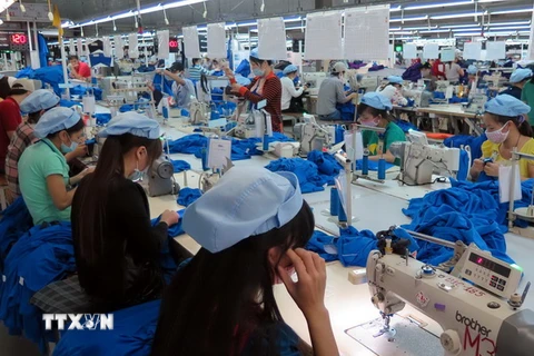 May áo quần xuất khẩu tại Công ty Cổ phần Dệt may Huế. (Ảnh: Quốc Việt/TTXVN)