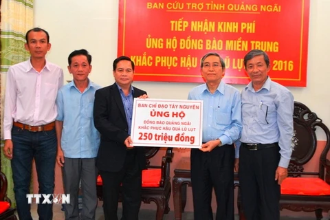 Phó trưởng ban Thường trực Ban Chỉ đạo Tây Nguyên Điểu K'RÉ trao tiền hỗ trợ cho đại diện Ủy ban Mặt trận Tổ quốc Việt Nam tỉnh Quảng Ngãi. (Ảnh: Phước Ngọc/TTXVN)