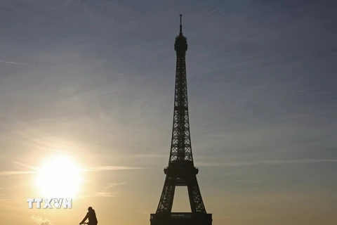 Người dân đạp xe gần khu vực tháp Eiffel ở Paris. (Nguồn: AFP/TTXVN)