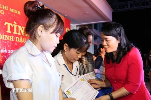 Lãnh đạo Thành phố Hồ Chí Minh và các doanh nghiệp trao tặng quà và tấm vé nghĩa tình cho công nhân về quê đón Tết. (Ảnh: Thanh Vũ/TTXVN)