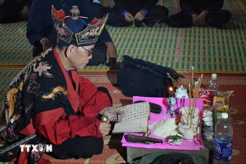 Một thầy Tào đang khấn lễ bằng chữ Nôm Tày. (Ảnh: Đức Hiếu/TTXVN)