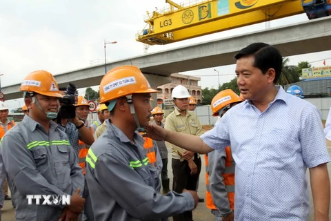 Bí thư Thành ủy Đinh La Thăng chúc Tết, động viên công nhân đang thi công công trình tại nút giao thông hoàn chỉnh, quận 9. (Ảnh: Thanh Vũ/TTXVN)