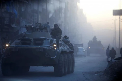 Binh lính Nga trên xe bọc thép tuần tra một đường phố ở Aleppo, Syria. (Nguồn: Reuters)