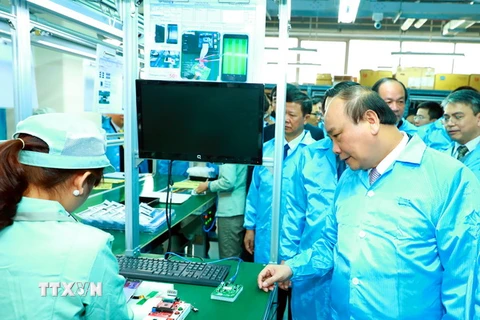 Thủ tướng Nguyễn Xuân Phúc thăm khu sản xuất của Công ty cổ phần Công nghệ công nghiệp Bưu chính viễn thông Việt Nam. (Ảnh: Thống Nhất/TTXVN)
