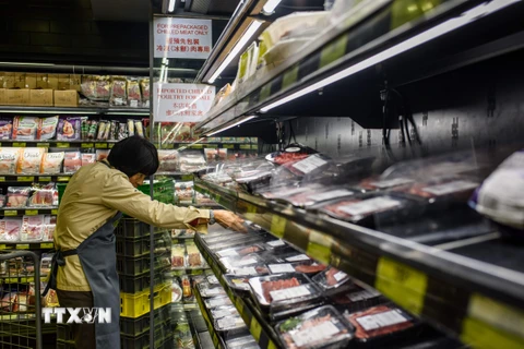 Nhân viên dỡ các gói thịt nhập khẩu từ Brazil xuống khỏi các kệ trong một siêu thị ở Hong Kong (Trung Quốc). (Nguồn: AFP/TTXVN)
